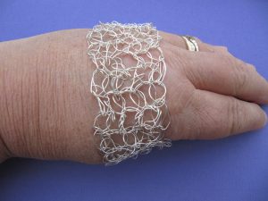 The crocheted bangle being slipped over the hand